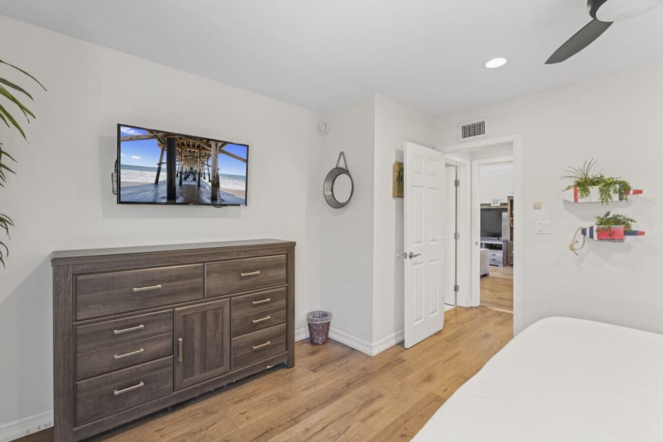 Bedroom dresser area w/ TV & easy access to hallway and adjoining spaces