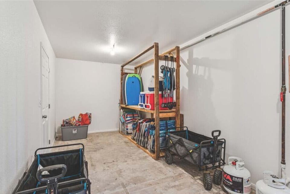 Spacious garage area w/ storage shelving, ideal for keeping gear organized