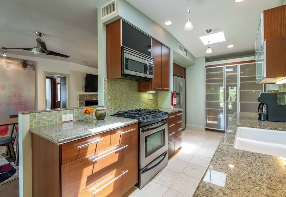 Sleek galley kitchen with stainless appliances & ample prep space