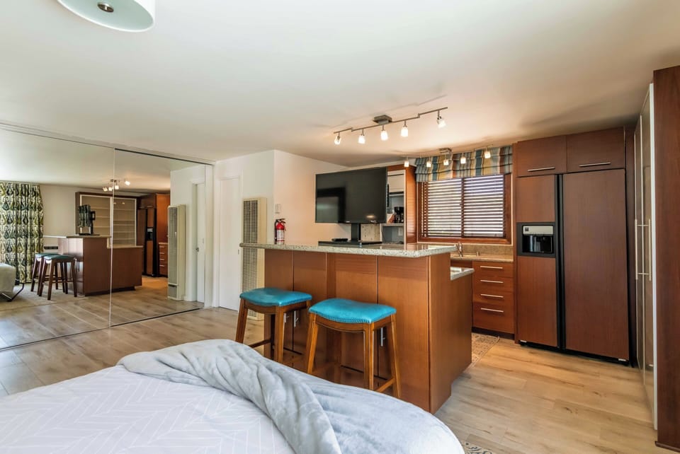 Studio view with Murphy bed setup, kitchen island & seating