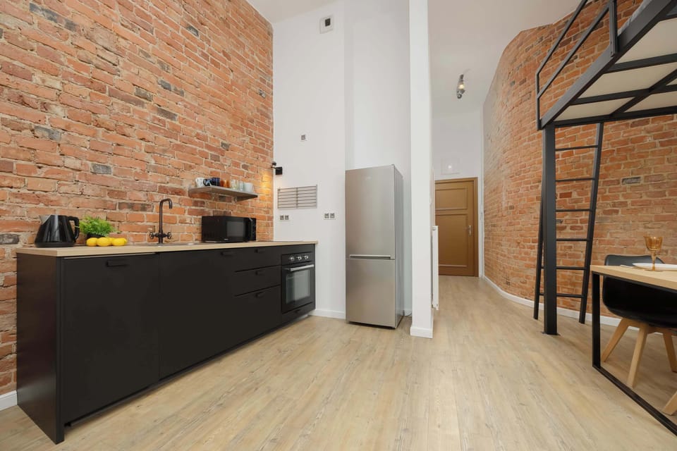 Fully equipped kitchen with wooden countertop and dark cabinetry.