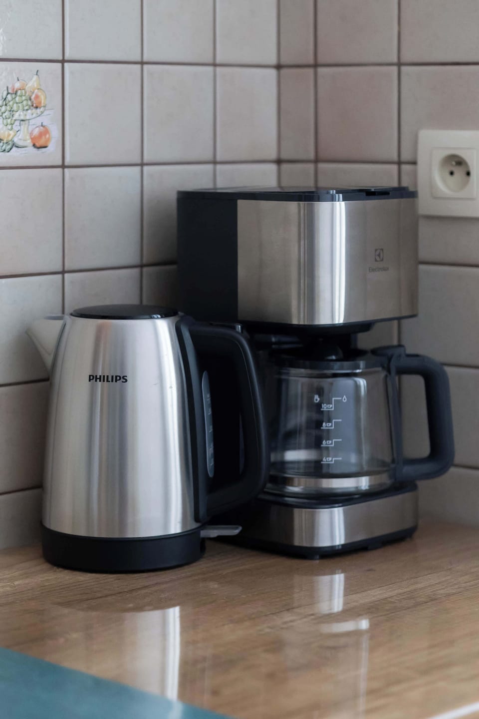 Modern countertop setup with kettle, coffee maker, and cooking essentials.