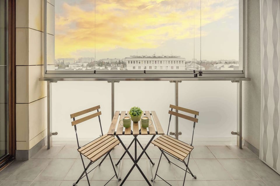 A compact café-style table set by the panoramic window provides the perfect spot for breakfast with a view, adding a light and urban charm to the stay.
