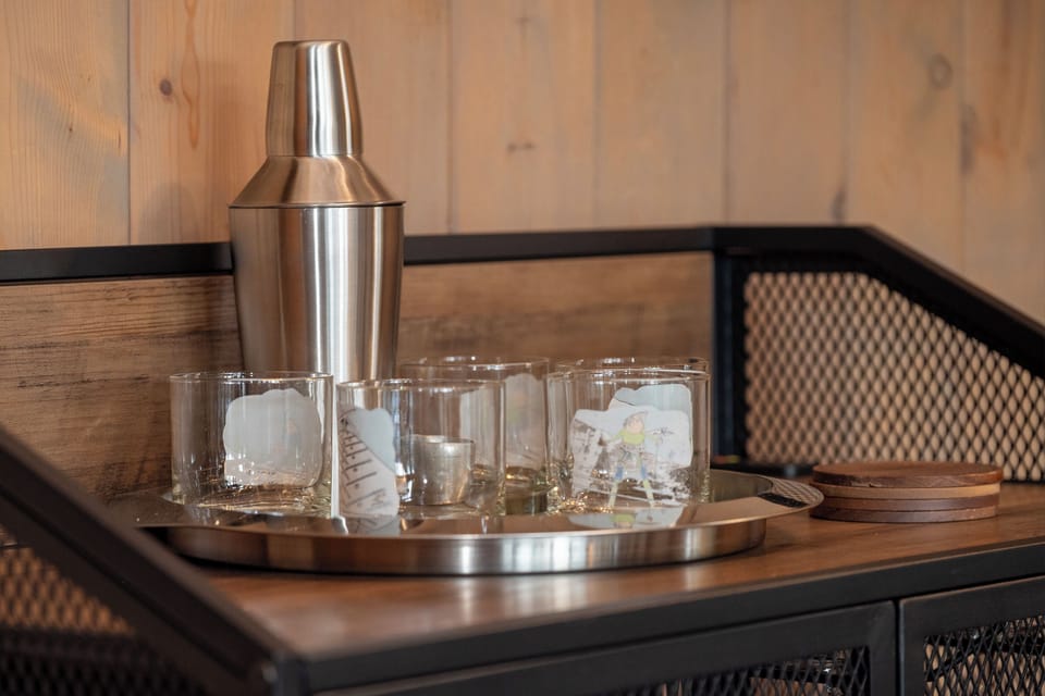 Mix your favorite cocktails with this stylish bar setup, complete with shaker and glassware for memorable evenings.