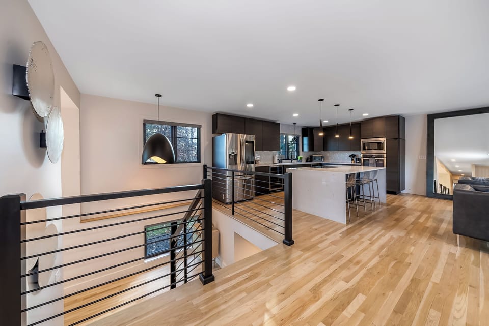 Your open-concept kitchen flows seamlessly with hardwood floors and sleek modern design, perfect for cooking and entertaining.