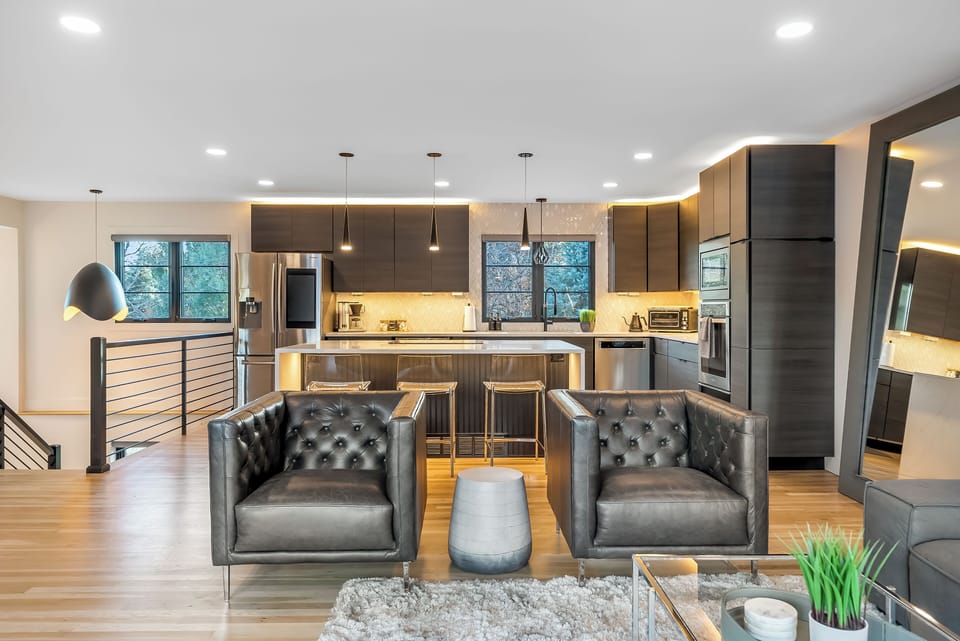 Relax in your sleek open-plan living space where modern design meets comfort, featuring a gourmet kitchen and cozy seating area.