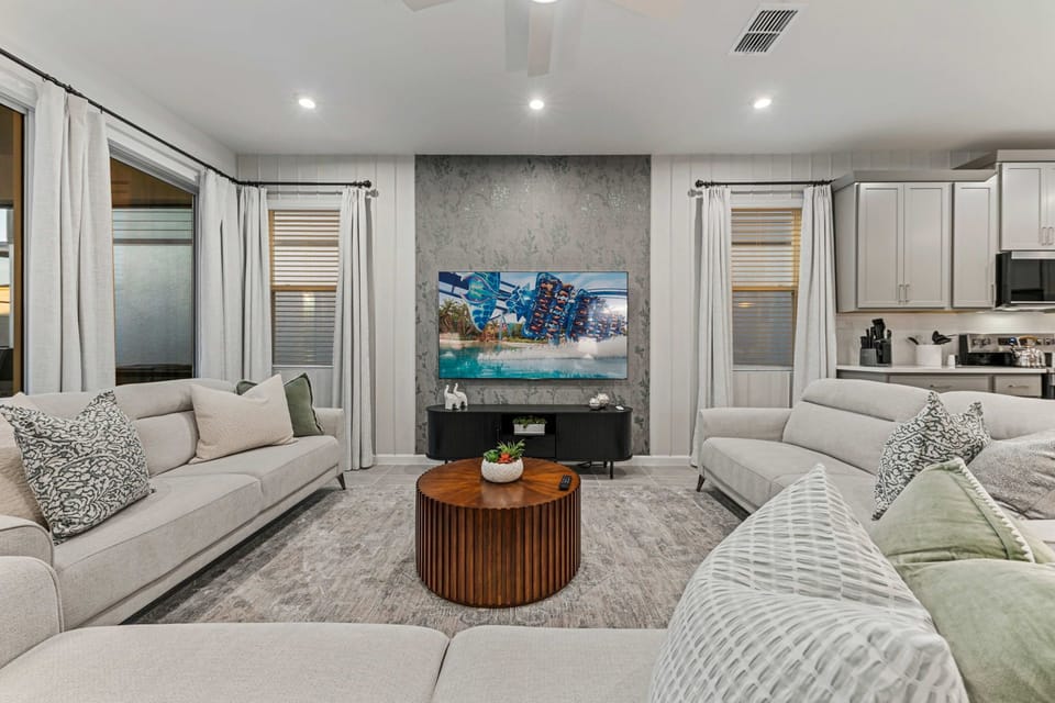 Stylish open living room with bright natural light and views of the private pool.