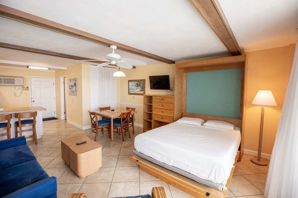 The studio's versatile design showcases the Murphy bed in a convenient setup, seamlessly blending a functional living area with stylish décor, perfect for a beach getaway.