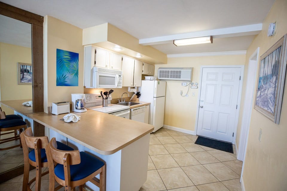 The fully equipped kitchen offers modern appliances and ample counter space, making meal preparation easy and enjoyable during your beachfront stay.