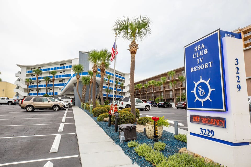 The vibrant exterior of Sea Club IV Resort welcomes guests with colorful balconies and a tropical atmosphere.