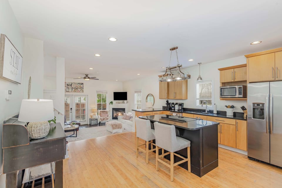 Sleek, open-concept kitchen with stainless steel appliances, island seating, and all amenities.