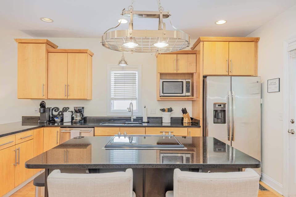 Fully equipped kitchen with a large island, stainless steel appliances, and island seating.