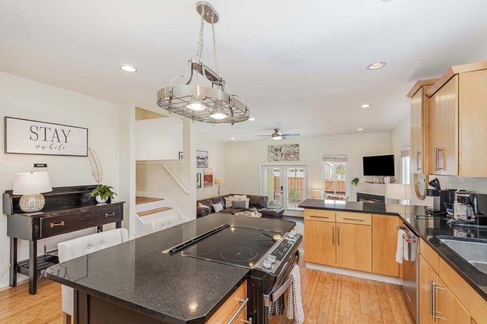 Sleek, open-concept kitchen with stainless steel appliances, island seating, and all amenities.