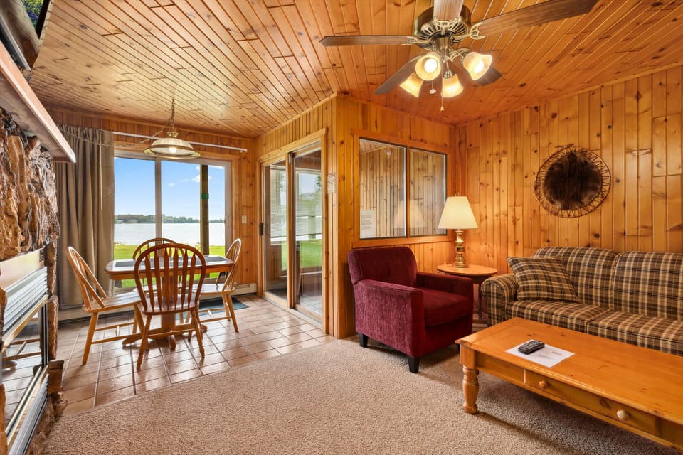 Bright dining nook and living space with large windows framing lake views.