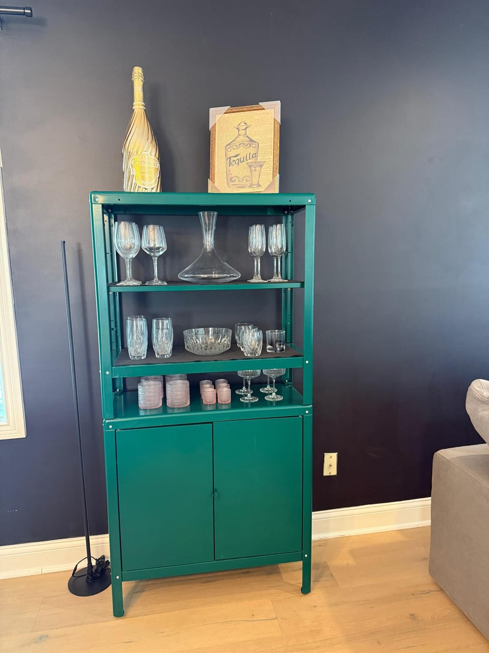 Elegant crystal glasses displayed on a chic green shelf.