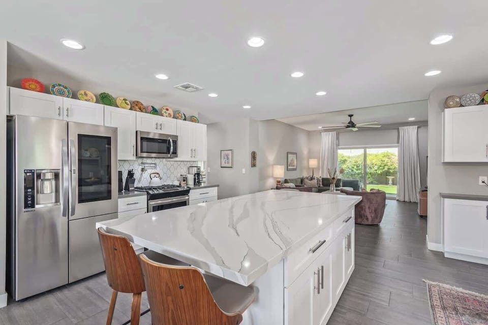 Chef's kitchen with huge island with 4 swivel stools, 4-burner gas range with pot filler, quartz countertops and just about every kitchen gadget you need to make meals at home.