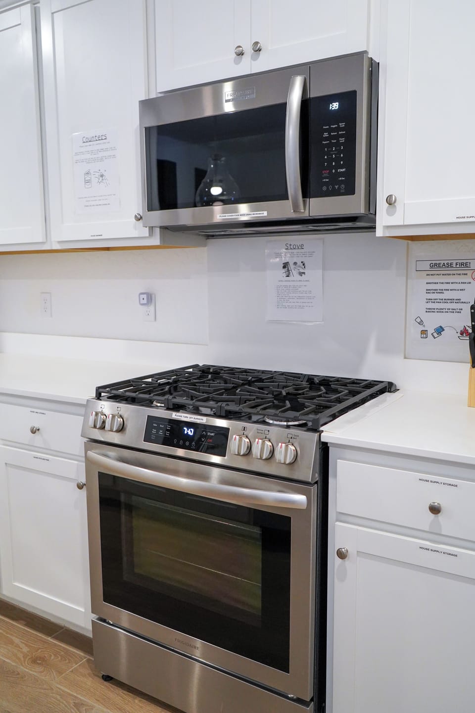 Sleek white kitchen with bright counters, modern appliances, and full setup.