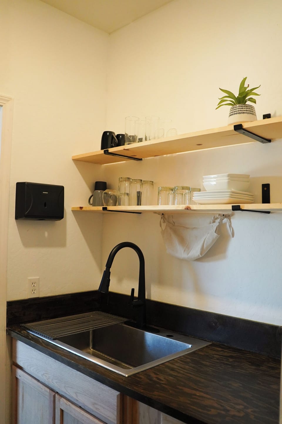 Kitchen stocked with mugs, cups, bowls, plates and all essentials.