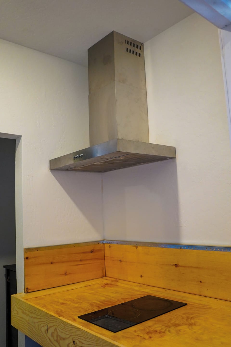 Fan above electric stove for ventilation, keeping cooking smoke-free.