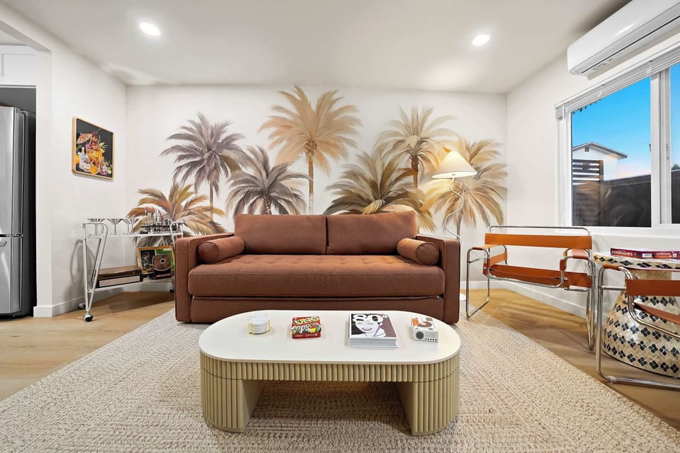 Spacious lounge area featuring a comfy sofa and coastal wall mural.