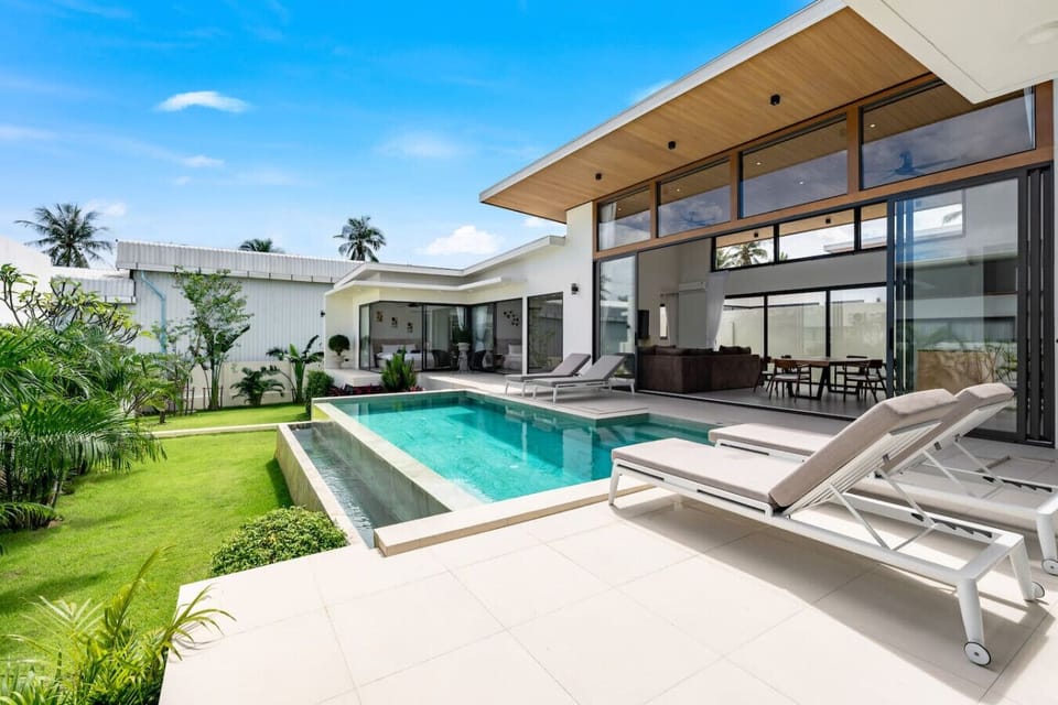 Private pool with cascading edge, sun loungers, tropical lawn and modern villa architecture - Green Garden Villa Bophut