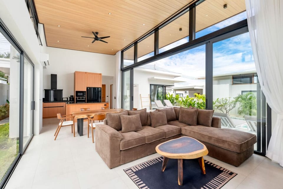 Spacious open-plan living room with comfortable sectional sofa, dining area and garden views - modern Green Garden Villa