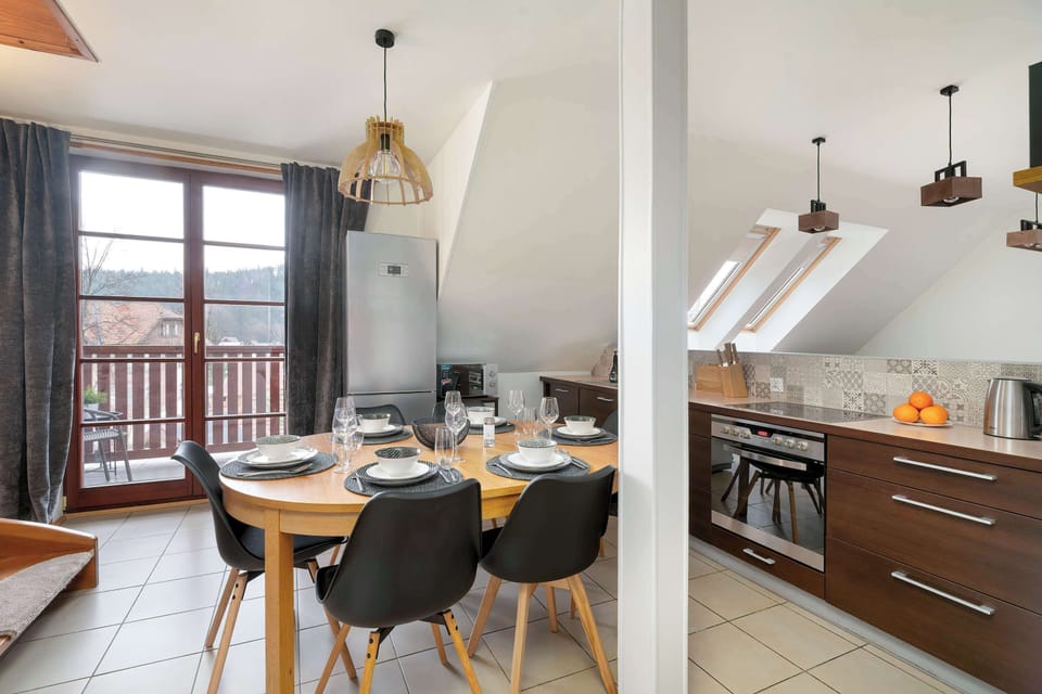 Bright dining area beside the functional kitchenette with warm wooden details.