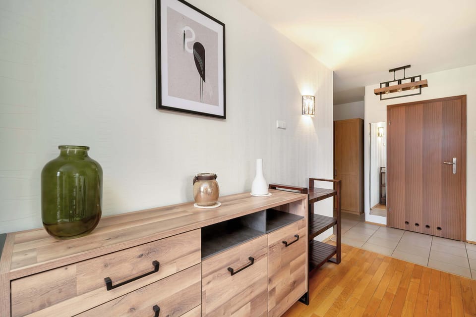 Tasteful hallway with a decorative wooden dresser and subtle natural accents.