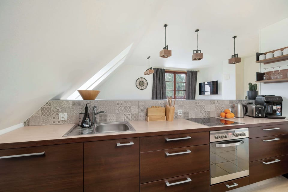 Modern kitchenette with elegant wooden cabinets and atmospheric ceiling lighting.