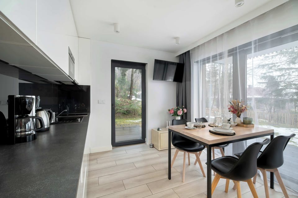 The studio’s kitchen and dining area blend seamlessly in an open layout. Large windows bring in plenty of daylight and offer views toward the terrace.