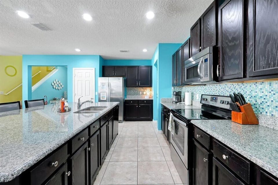 Cook with ease in this modern, fully equipped kitchen featuring granite countertops, stainless steel appliances, and plenty of space for meal prep.