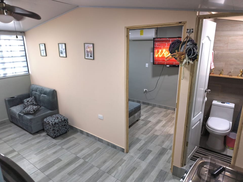Área cómoda con sofá y acceso directo a dormitorio y baño.