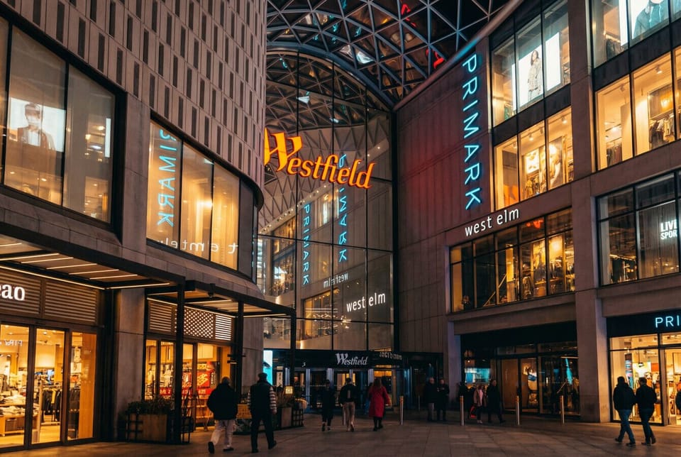 The entrance to Westfield Stratford City shopping centre, showing a large retail complex with multiple well-known stores.