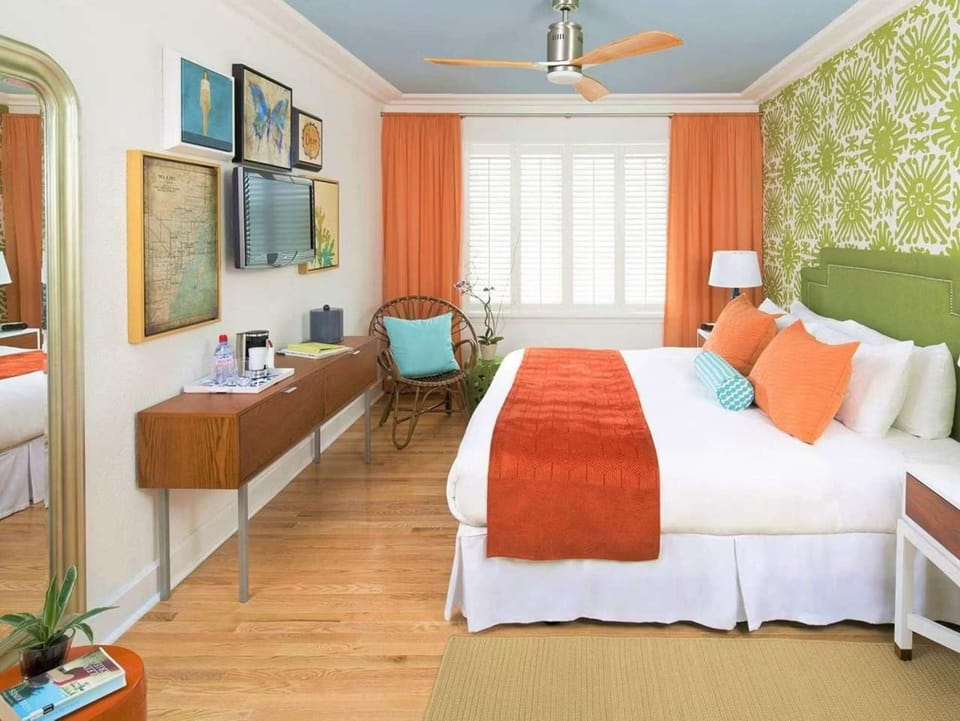 Colorful room with bed, green wall and bright coral details