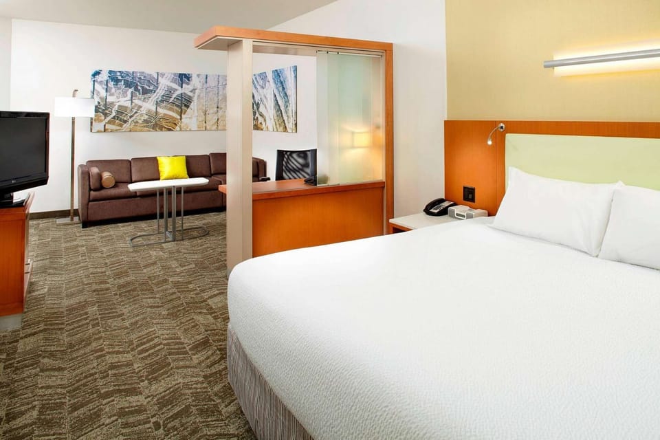 King bed with desk divider and sofa seating in spacious suite