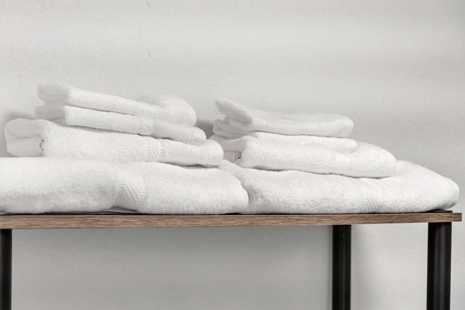 white towels on wooden table near the bathroom area