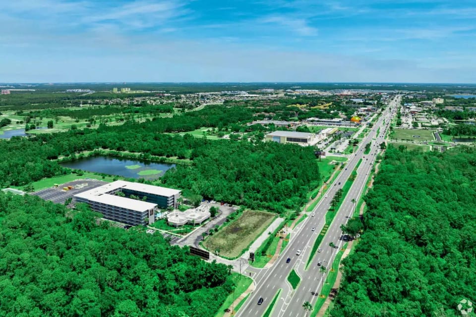Aerial view of area with roads, trees, and buildings