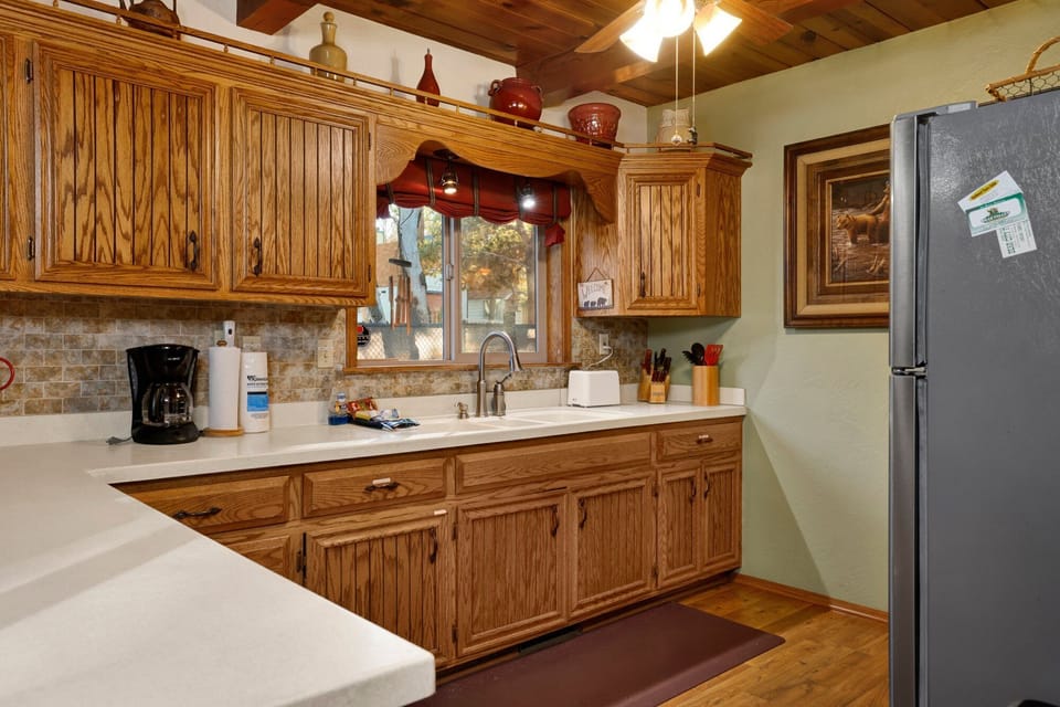 Fully equipped cabin kitchen with ample cabinetry, stove, fridge, microwave, and coffee maker perfect for cooking meals, morning coffee, and feeling right at home on your stay.