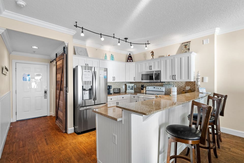 There is a dining table, perfect for enjoying a meal or playing a game, as well as additional breakfast bar seating.