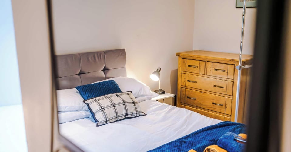 A cozy serene retreat with soft lighting, plush bedding, and a calming color palette. Thoughtful storage and tidy furnishings make it a clutter-free space, ideal for restful nights and relaxing mornings.