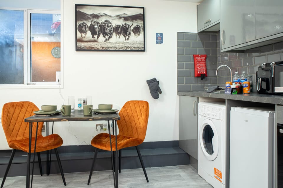 Dining area with table for two and integrated kitchen facilities, designed for comfortable short or longer stays.