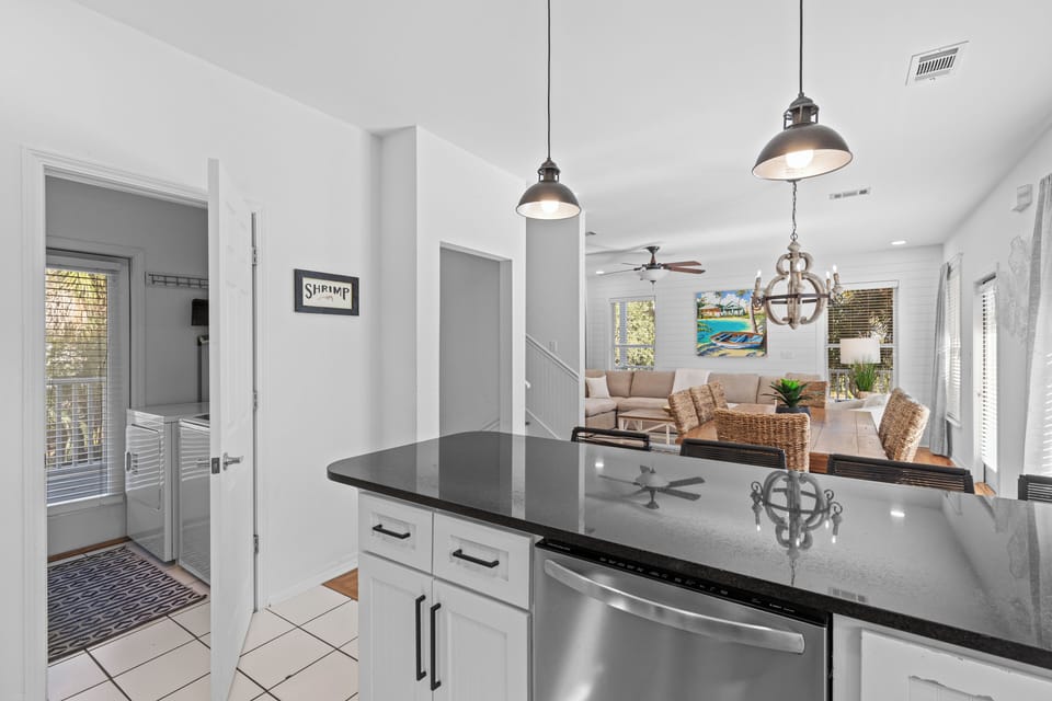 Your sleek kitchen island overlooks the open living space, where coastal charm meets modern comfort in this beautifully designed retreat.