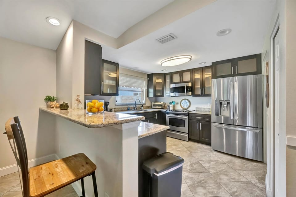 Modern kitchen with breakfast bar, stainless appliances, and easy open-concept flow.
