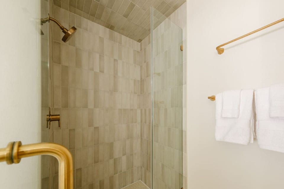 The main primary suite bathroom includes a hand-tiled walk-in shower.