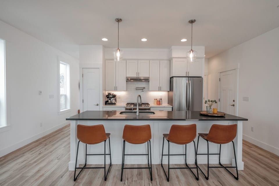 The expansive island offers relaxed seating for four, creating a perfect gathering spot for morning coffee or evening conversation.