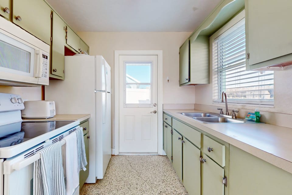 This bright, functional kitchen is perfect for your beach stay, featuring coastal-style cabinetry and all the essentials for easy meals. Ideal for fueling up before the beach or winding down after a sunny day.