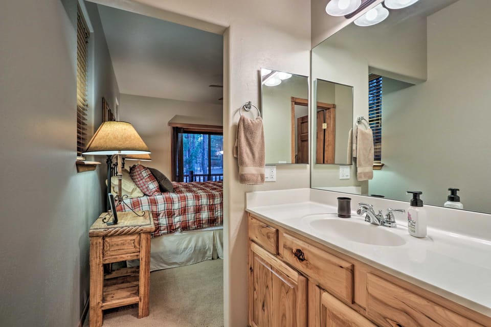 A bathroom vanity area opens directly into a furnished bedroom.