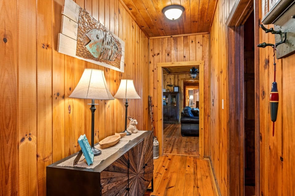 A welcoming hallway lined with natural wood and soft lighting creates a warm entrance to the living spaces, setting the tone for a relaxing mountain stay.
