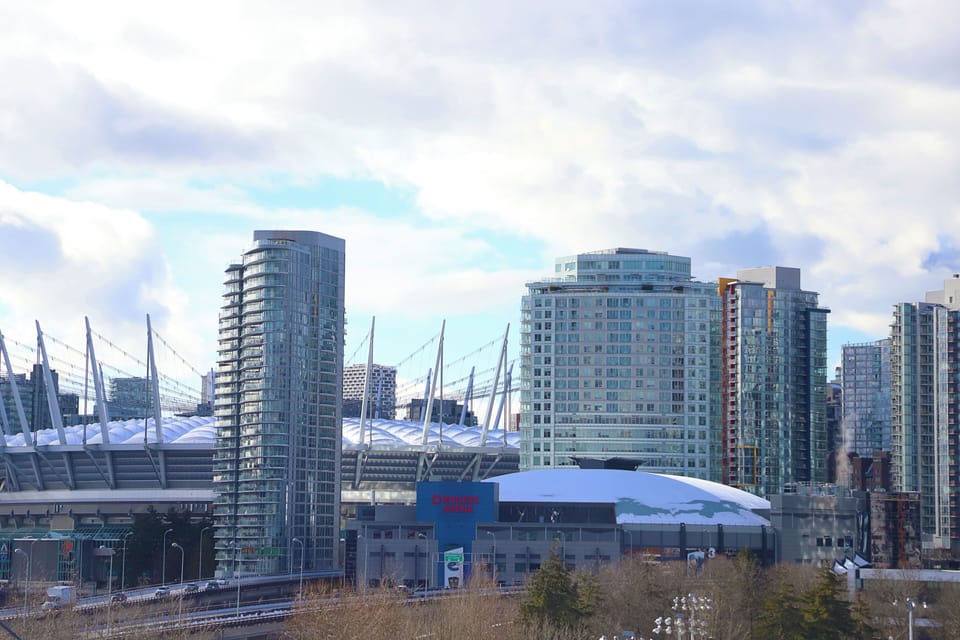 View of Vancouver landmarks: Rogers Arena, BC Place. Lights up at night.