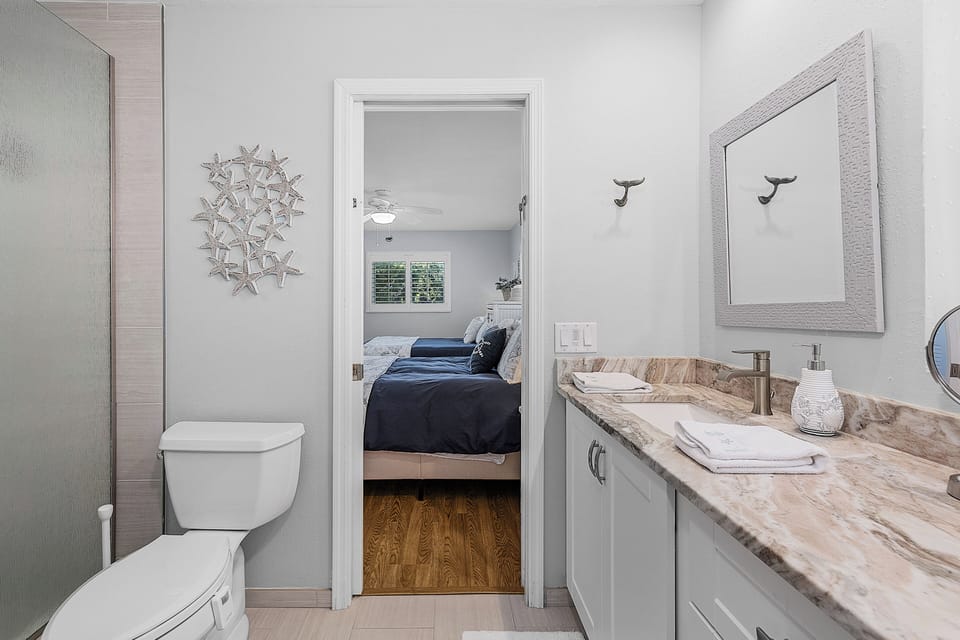 Shared bathroom with vanity and storage
